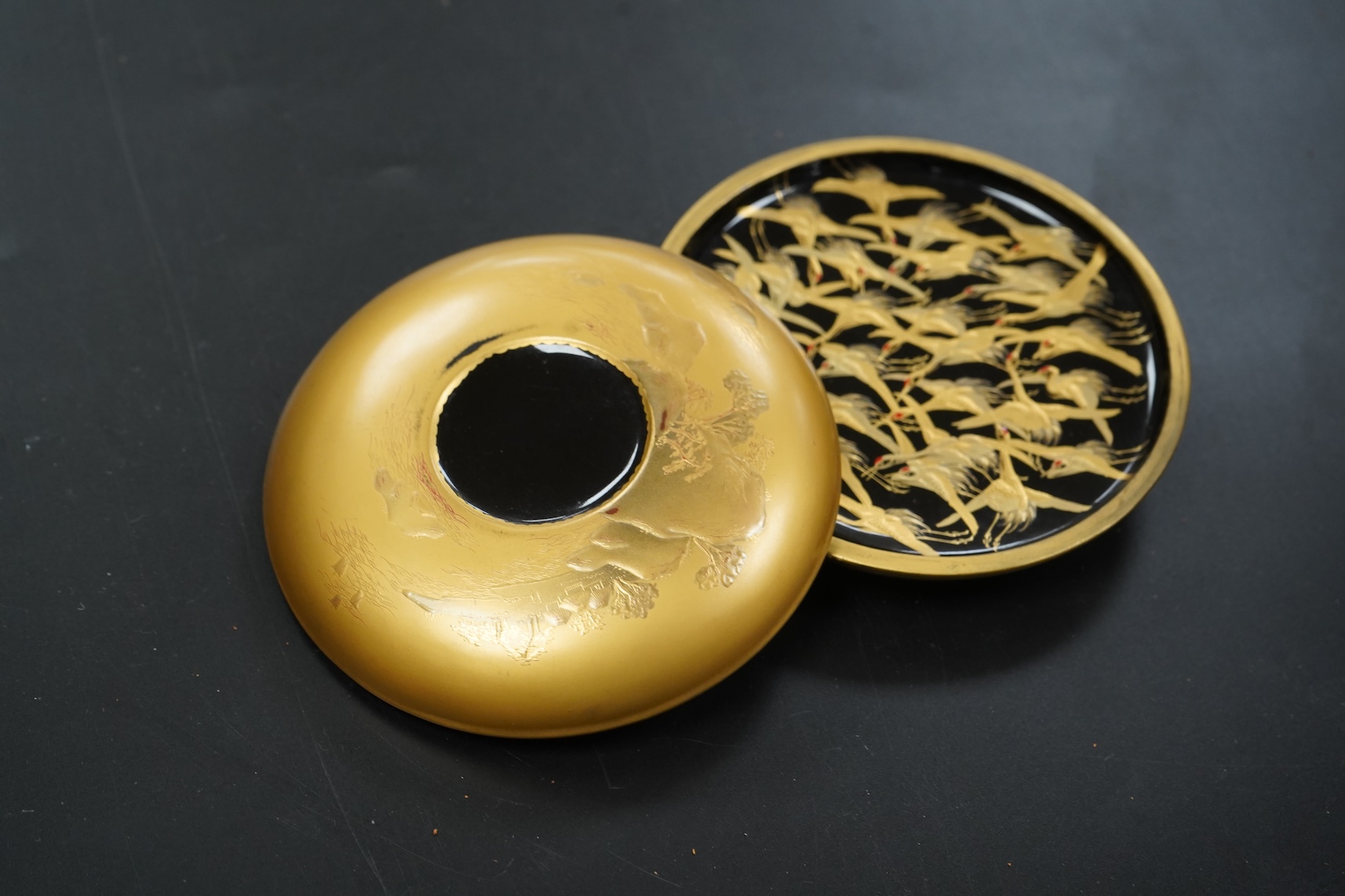 A Japanese circular gilt lacquer box decorated in relief, with paperwork, 10cm in diameter